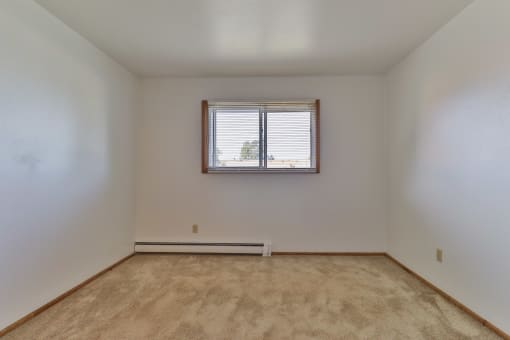 the bedroom of an empty house with a window