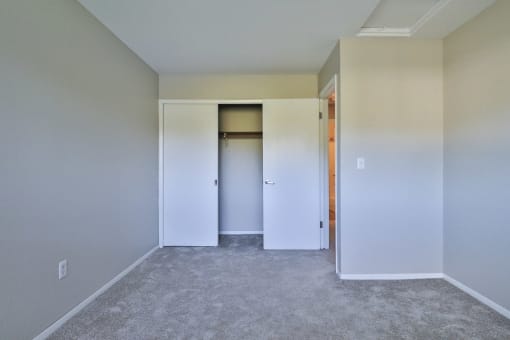 an empty room with white walls and a closet