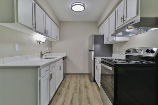 the preserve at ballantyne commons apartment kitchen with white cabinets and black appliances