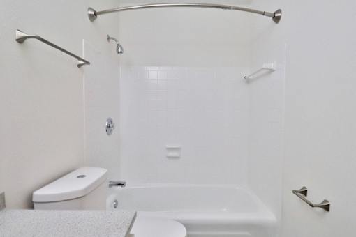 a white bathroom with a shower and a toilet