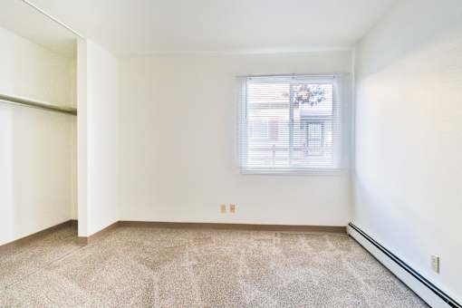 A room with a window and carpeted floor.