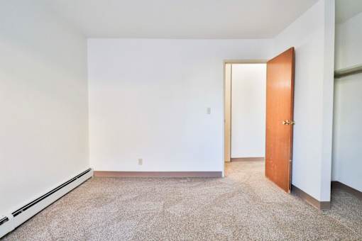 A room with a carpeted floor and a door.