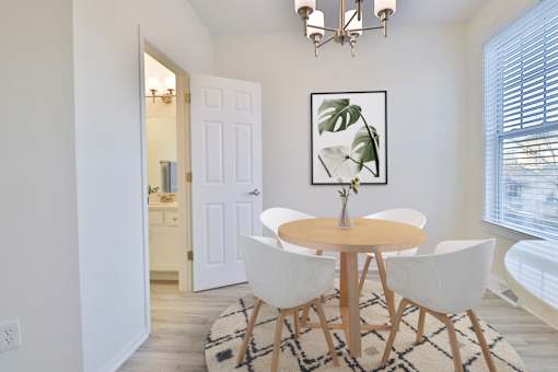 A dining room with a round table and chairs.