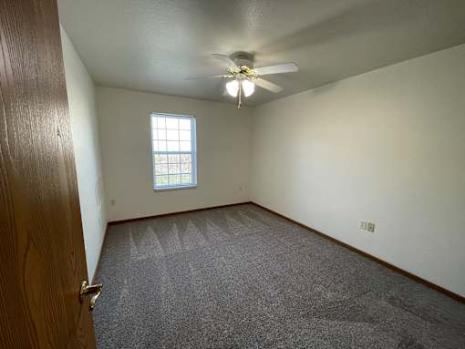 A room with a ceiling fan and a window.