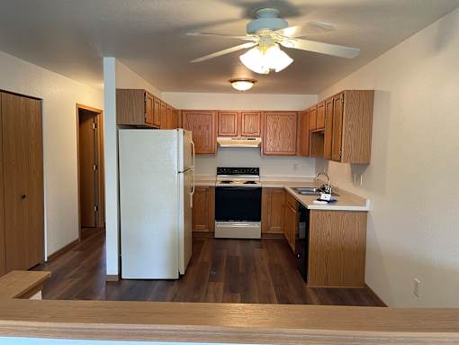 A kitchen with wooden cabinets and a white refrigerator.