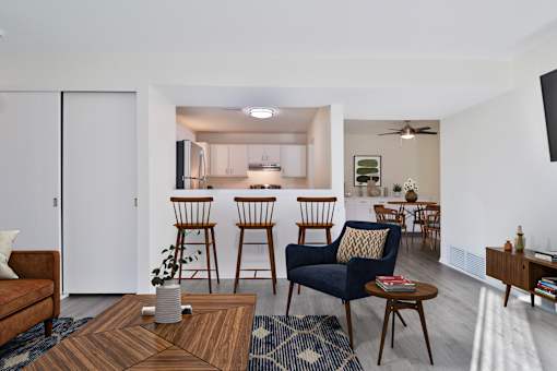 A living room with a brown coffee table and blue chairs.