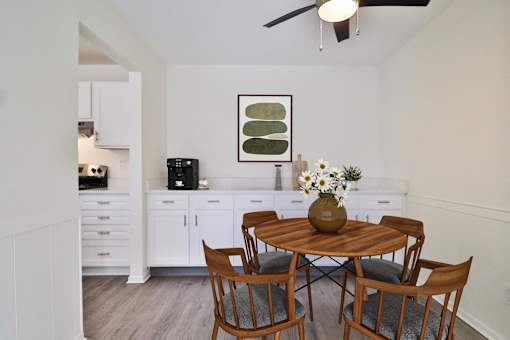 A dining room with a wooden table and chairs.