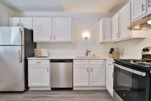 A kitchen with white cabinets and appliances.