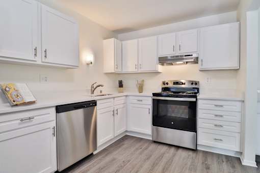 A kitchen with white cabinets and stainless steel appliances.