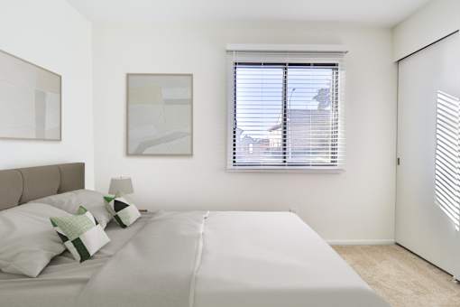 A bedroom with a large bed and two framed pictures on the wall.