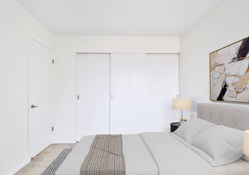 A bedroom with a large bed and a painting on the wall.