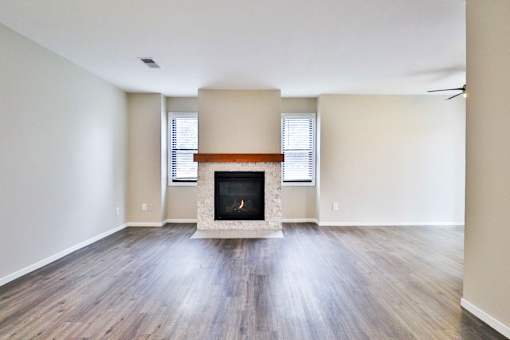 A room with a fireplace and wooden floors.