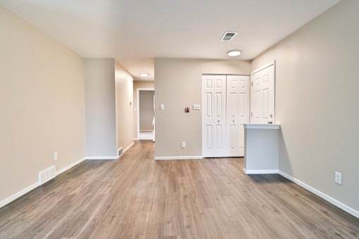 A room with wood flooring and white walls.