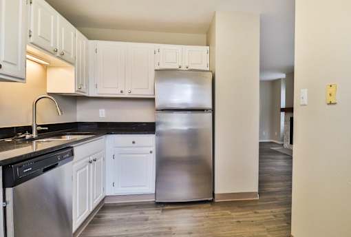 A kitchen with white cabinets and a black dishwasher.