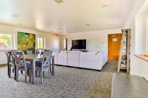 A living room with a grey carpet and a white sofa.