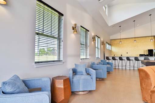 A living room with blue chairs and a brown couch.