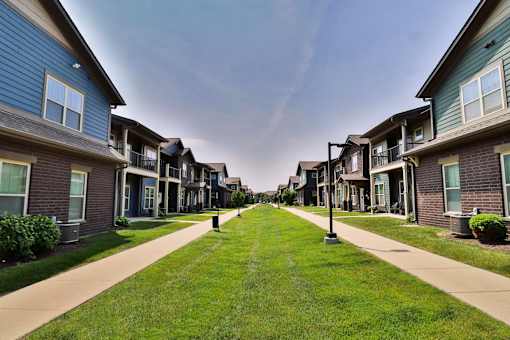 A row of houses with a sidewalk in front.