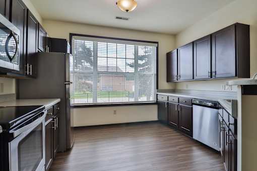 A kitchen with black cabinets and stainless steel appliances.