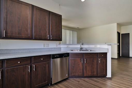 A kitchen with dark wood cabinets and stainless steel appliances.