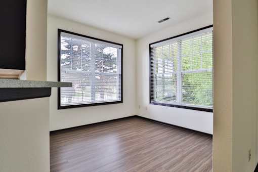 A room with a window overlooking a tree-filled yard.