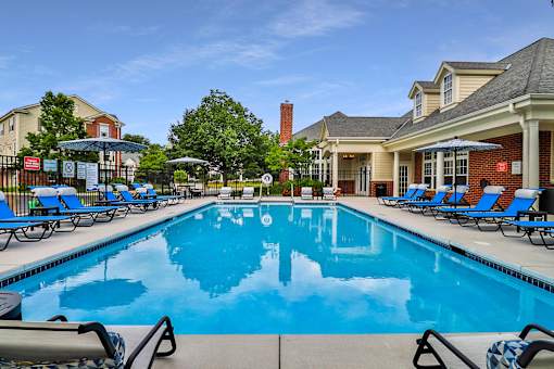 A large swimming pool with lounge chairs and umbrellas.