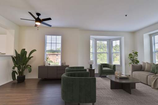 A living room with a ceiling fan and a green chair.