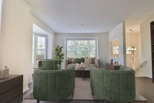 A living room with two green chairs and a couch.