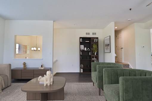 A living room with a brown coffee table and green chairs.