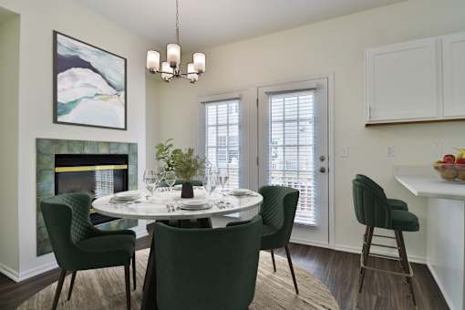 A dining room with a white table and green chairs.