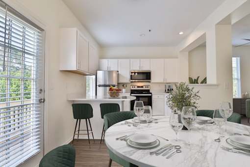 A modern kitchen with a dining table set for two.