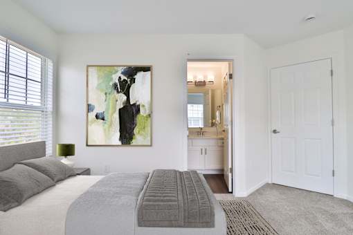 A bedroom with a large bed and a painting on the wall.