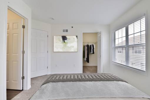 A bedroom with a large bed and a painting on the wall.