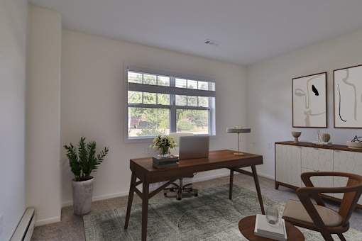 A room with a desk, chair, and a potted plant.
