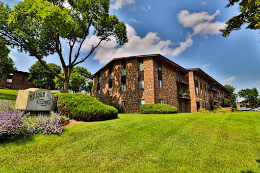 A building with a sign that says "Willisville Apartments" in front of it.