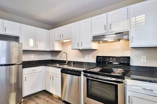 A kitchen with white cabinets and a black stove top.