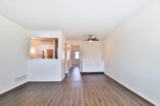 A room with a ceiling fan and wooden flooring.