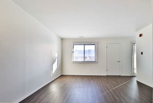A room with a window and wooden floors.