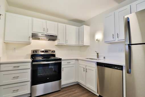 A kitchen with white cabinets and stainless steel appliances.