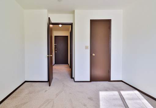 A hallway with two doors, one open and one closed.