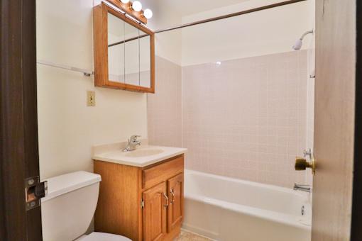 A bathroom with a toilet, sink, and bathtub.