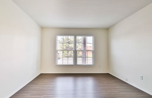 A room with a large window and wooden flooring.