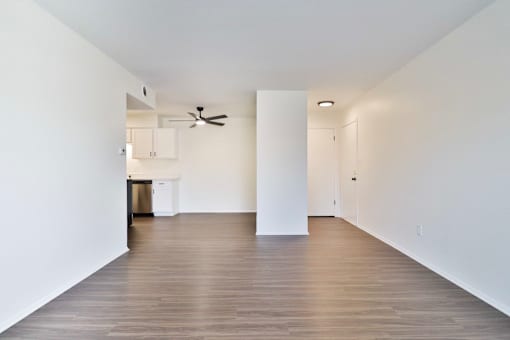 A long hallway with a fan and a door on the right.