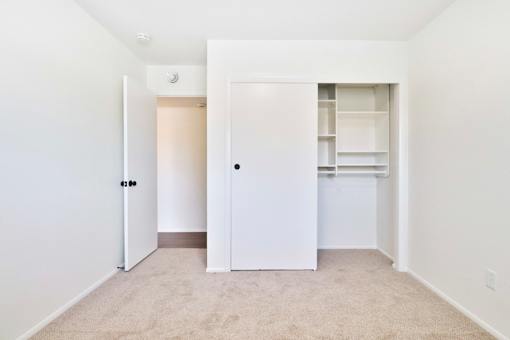 A white door is open to a room with a carpeted floor.