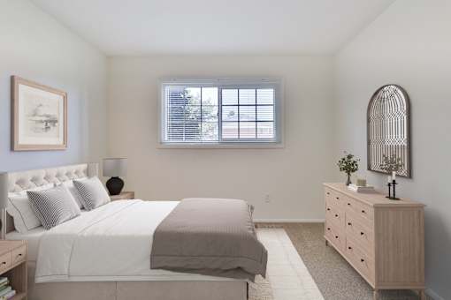 A bedroom with a large bed, a dresser, and a window.