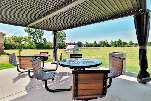 A patio with a table and chairs under a canopy.