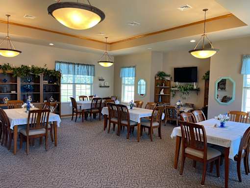 A large room with tables and chairs set up for a meeting or event.