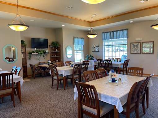 A dining room with a table set for a meal.