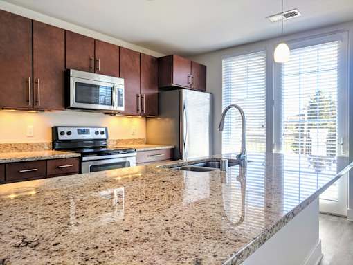A kitchen with granite countertops and stainless steel appliances.