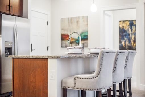 A kitchen with a white table and chairs.