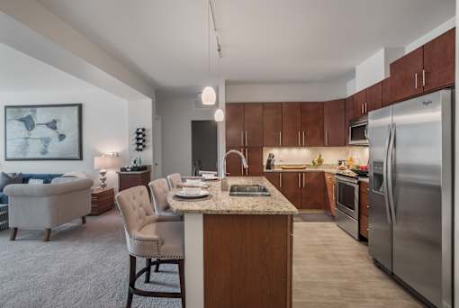 A modern kitchen with a refrigerator, oven, and sink.